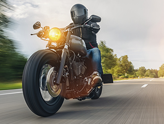 Motorcycle rider traveling down an open road representing freedom and motorcycle riding in Missouri.